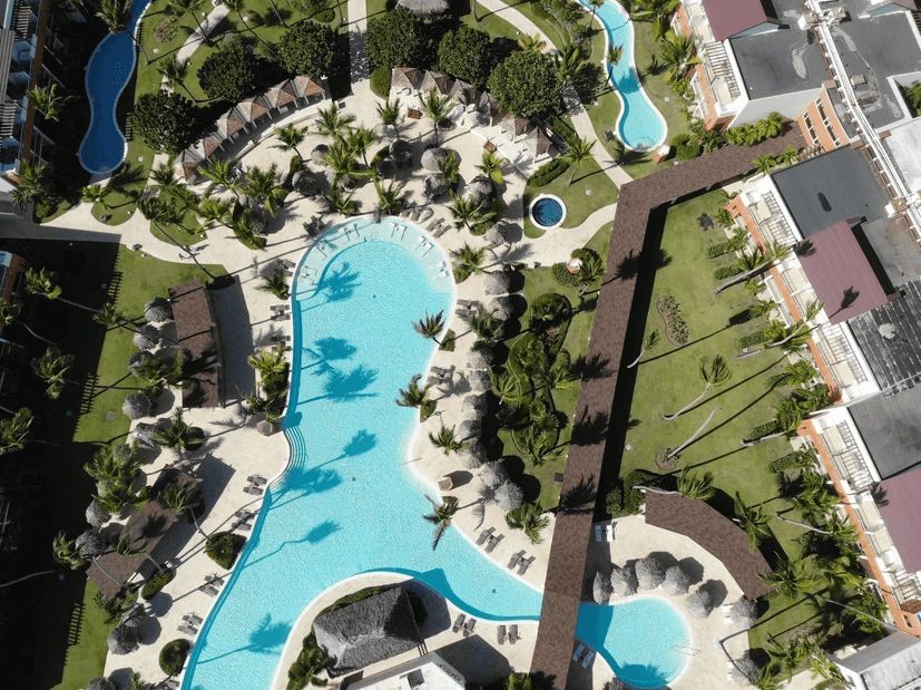 An aerial view of a large swimming pool surrounded by palm trees
