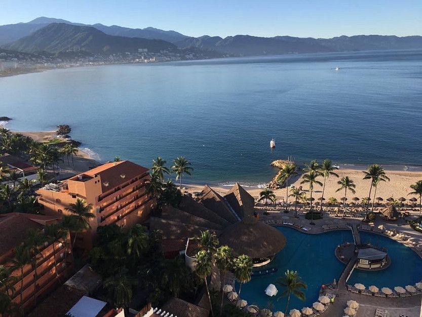 An aerial view of a large body of water surrounded by buildings and palm trees
