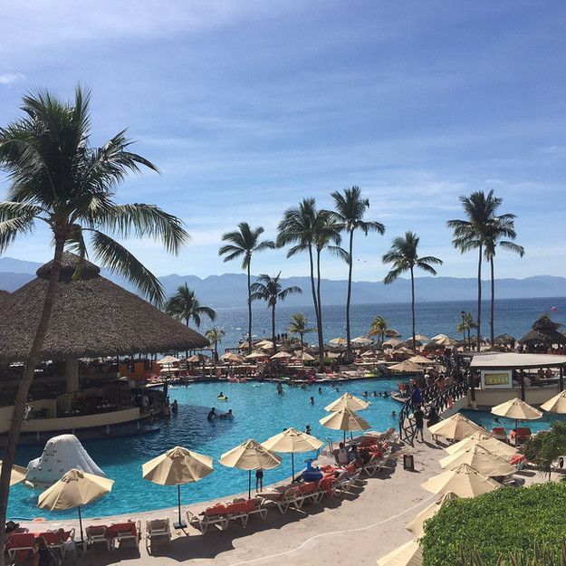 A large swimming pool surrounded by umbrellas and chairs