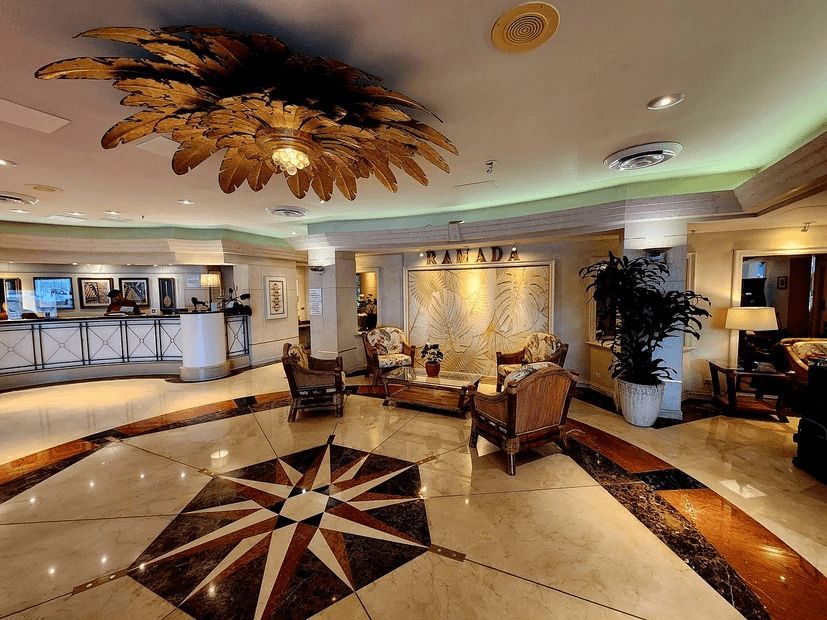 A hotel lobby with a palm tree shaped chandelier hanging from the ceiling.
