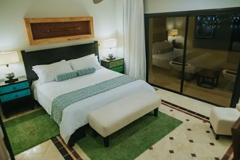 A hotel room with a king size bed and sliding glass doors