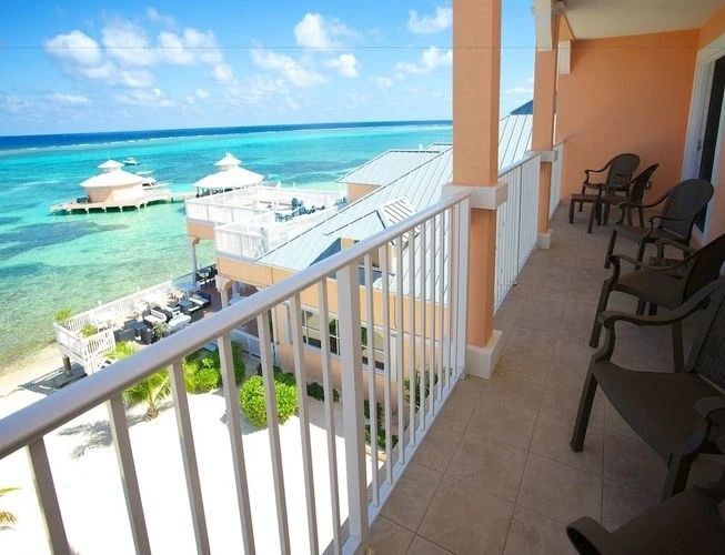 A balcony with chairs and a view of the ocean