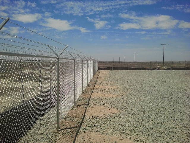 Chainlink fence surrounded with stones — Wood Fences in Bakersfield, CA