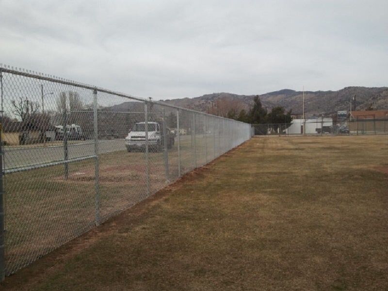 Chainlink fence in grass field — Wood Fences in Bakersfield, CA