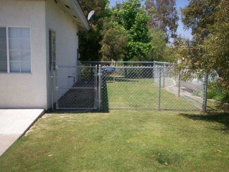 Chainlink fence gate in grass — Wood Fences in Bakersfield, CA