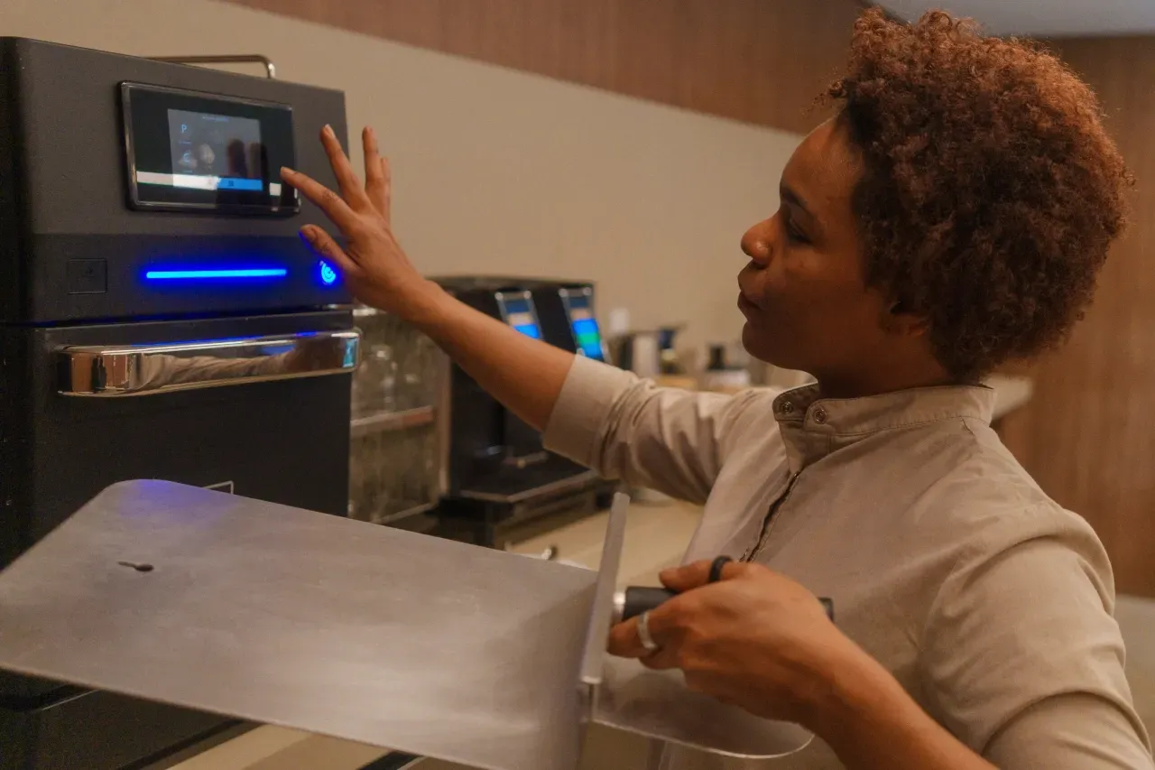 A professional operating Prática’s Fit Express Speed Oven using the touchscreen control panel