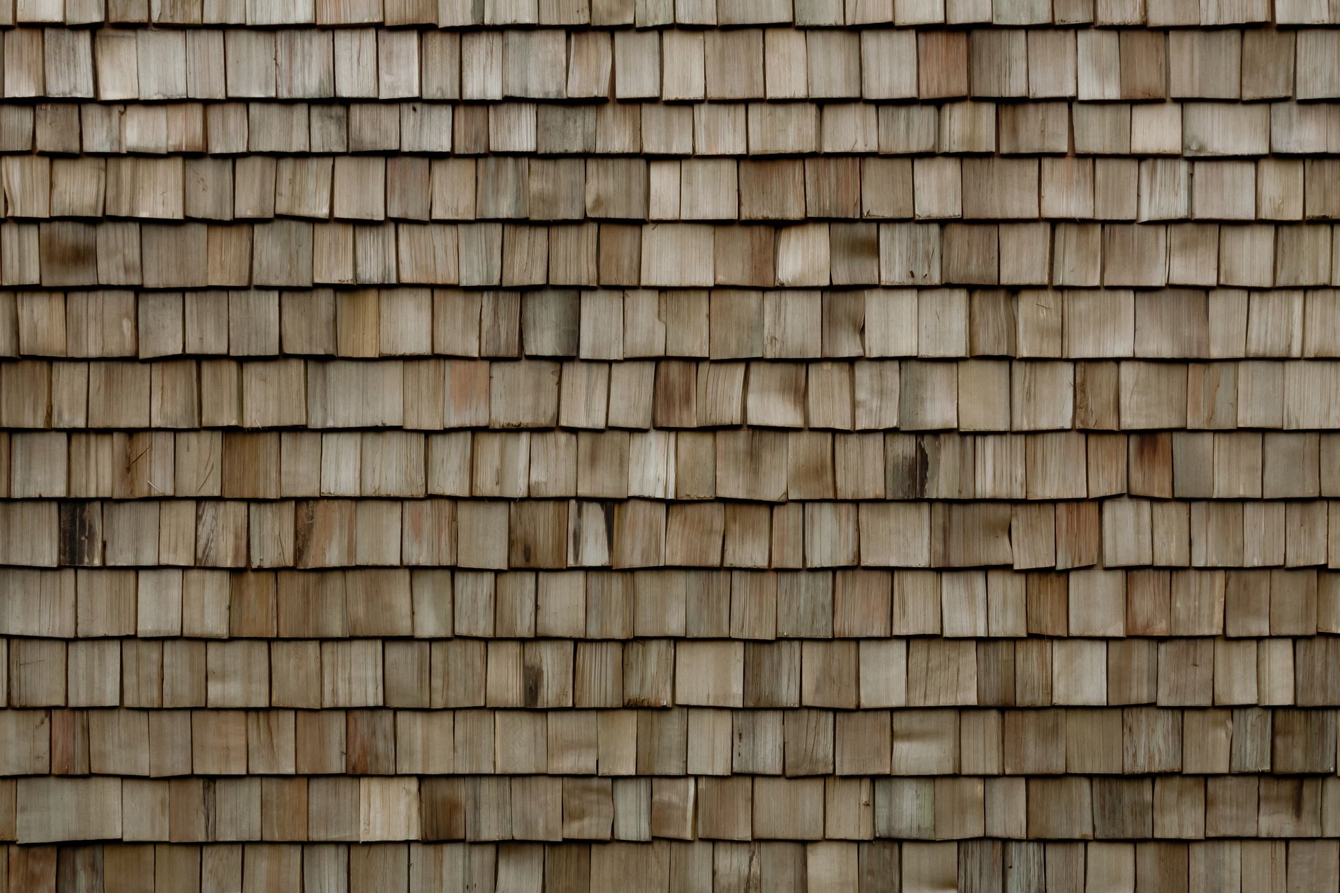 Close-up of weathered wooden shingles, varying shades of brown.