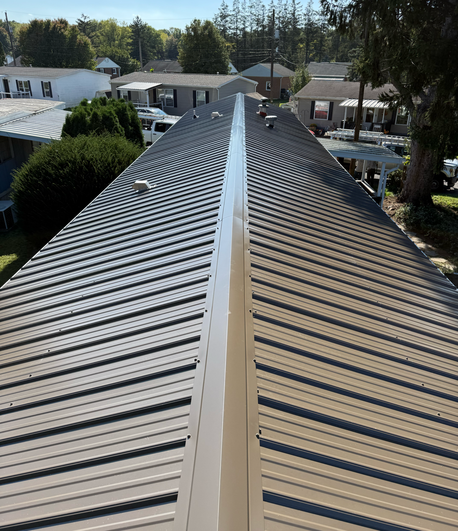 Metal roof, long building, gray and silver, bright day.