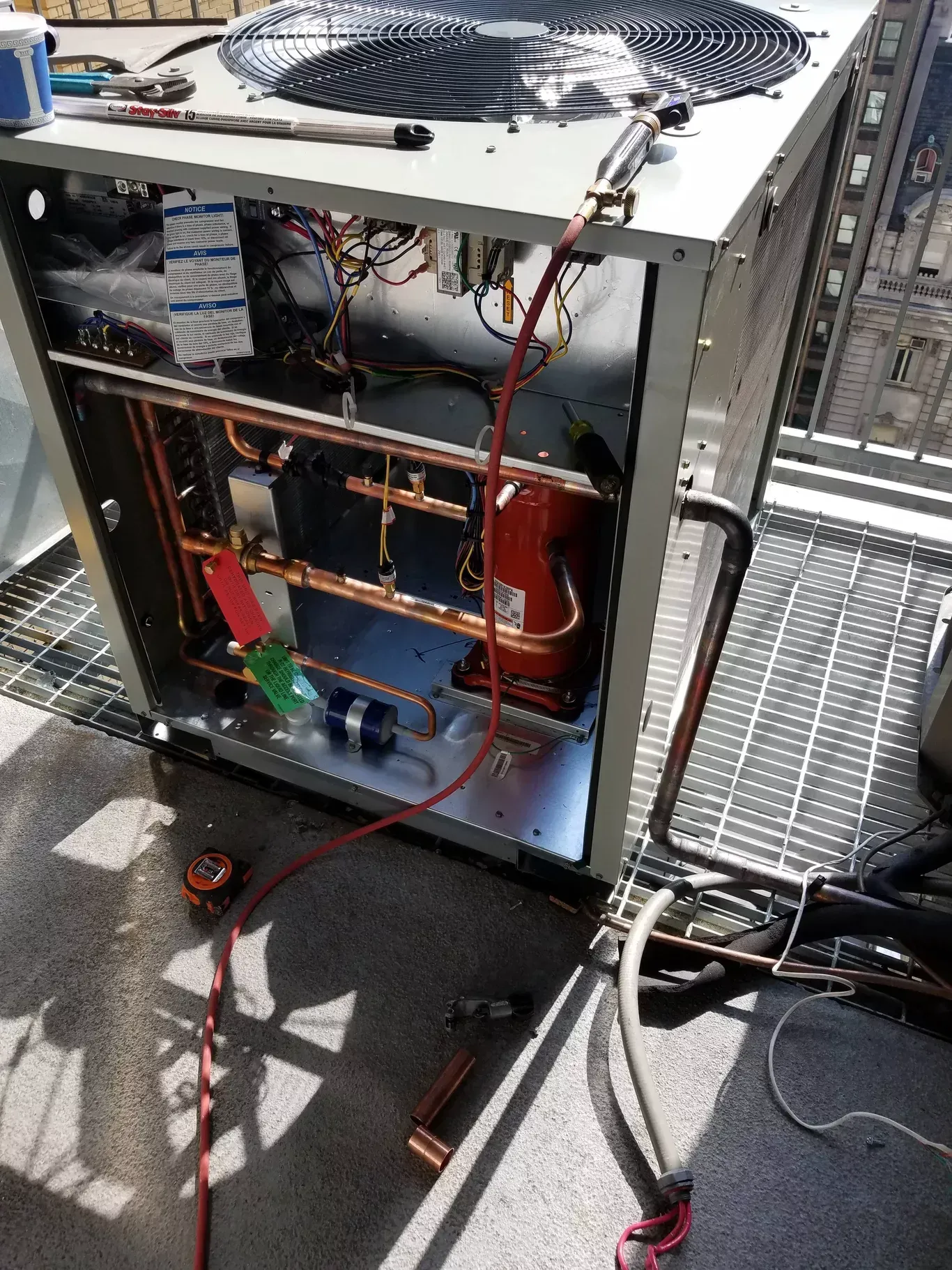 An air conditioner is being repaired on a concrete floor.