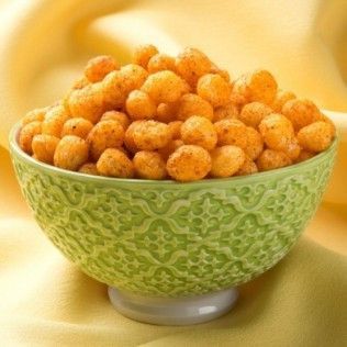 Green bowl filled with orange, crunchy peanut puffs.