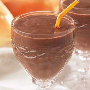 Chocolate milkshake in a decorative glass with an orange straw.
