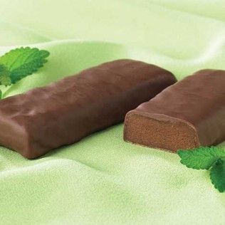Chocolate-covered mint patties on a light green cloth, garnished with mint leaves.