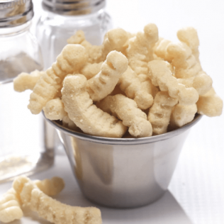 Bowl of light-colored, ridged snack puffs, with salt and pepper shakers in the background.