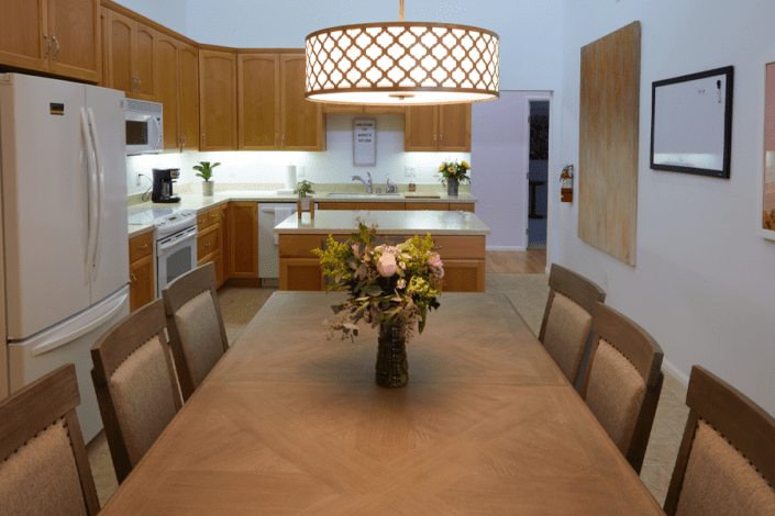 A dining room table with a vase of flowers on it