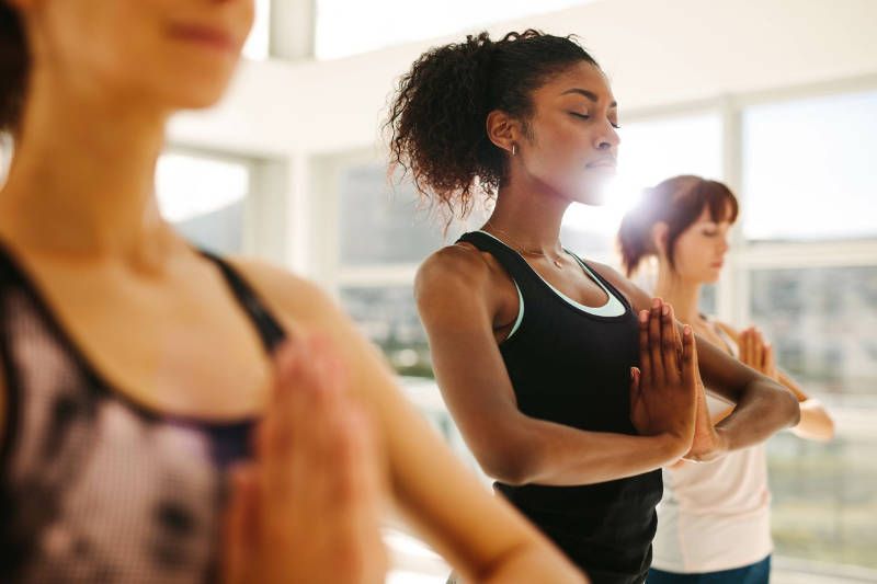 A group of women are practicing yoga in a gym.