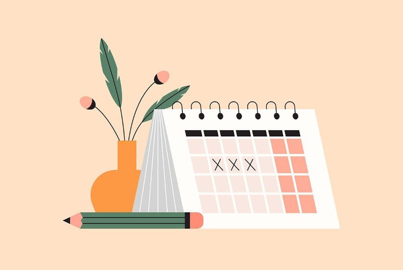 A menstrual cycle calendar with a vase of flowers and a pencil next to it.