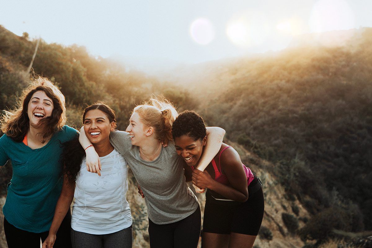 A group of women are standing next to each other on top of a hill.