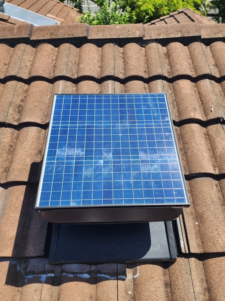 A Square Solar Panel on a Tiled Roof, Mounted Above a Dark Ventilation Box — Gold Coast Skylights in Slacks Creek, QLD