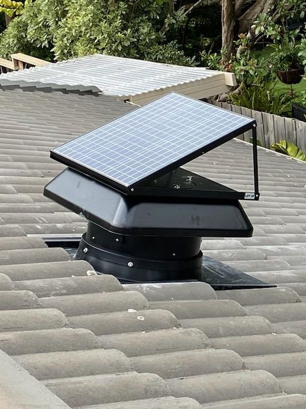 A Solar-powered Roof Vent With a Black Fan Sits on a Tiled Roof — Gold Coast Skylights in Robina, QLD