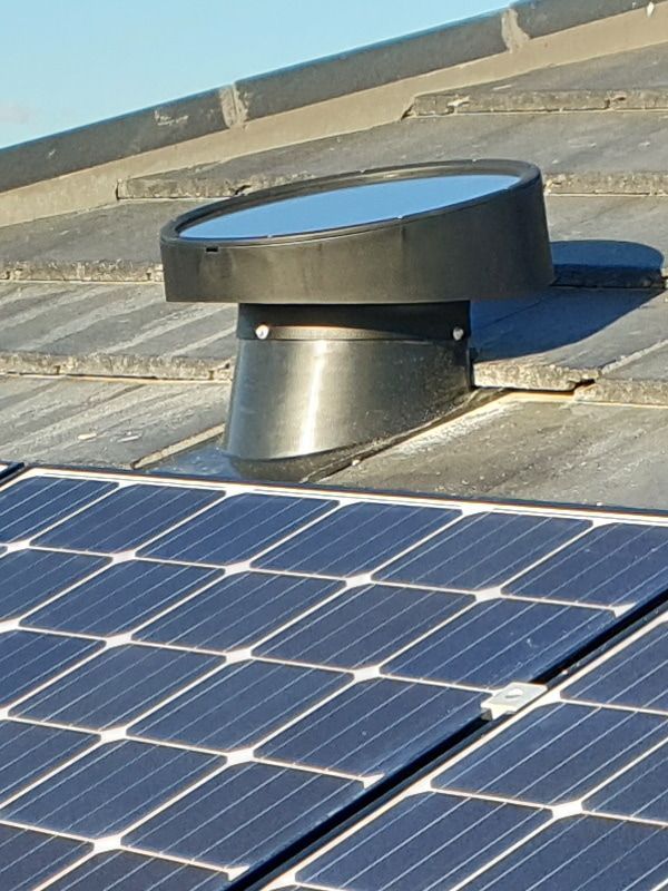 Black Solar Tube on a Rooftop With Gray Shingles, Near a Grid of Solar Panels — Gold Coast Skylights in Slacks Creek, QLD