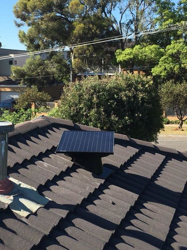 A Small Solar Panel Mounted on a Dark, Tiled Roof, Likely to Power a Vent Fan — Gold Coast Skylights in Helensvale, QLD