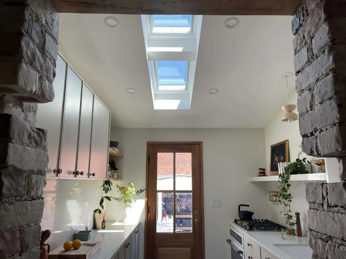 A Narrow Kitchen With White Walls, Cabinets, and Countertops, and a Skylight — Gold Coast Skylights in Oxenford, QLD