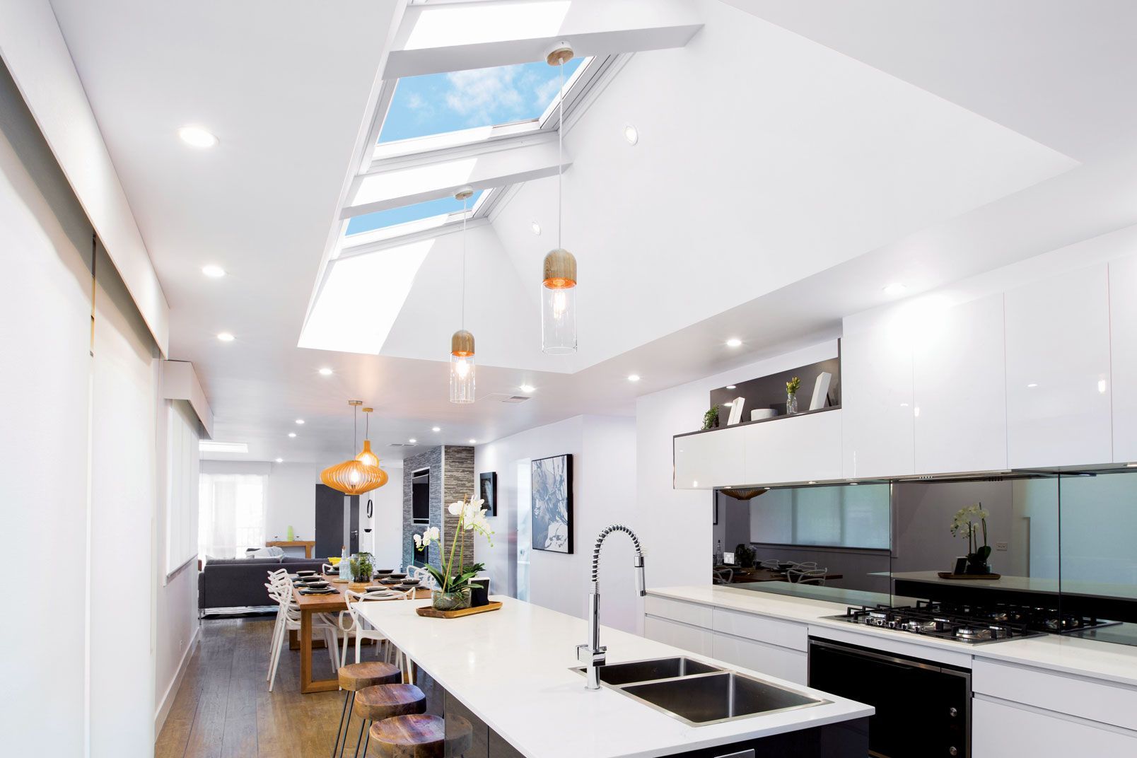 Modern Kitchen With a Large Island, White Cabinets, and Skylights Providing Natural Light — Gold Coast Skylights in Coolangatta, QLD