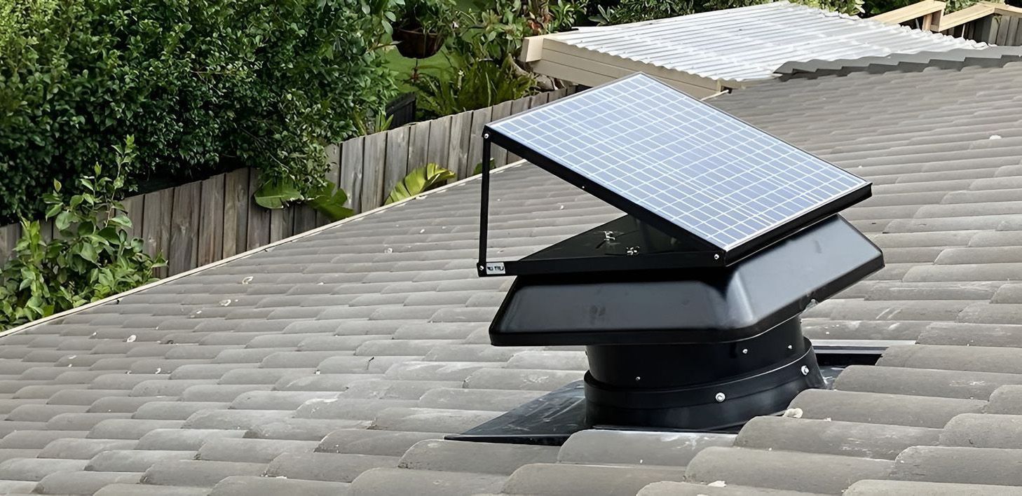 A Solar-Powered Roof Vent On A Grey Tiled Roof