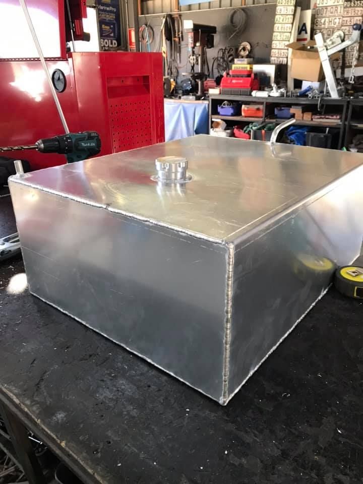A Large Aluminum Box is Sitting on a Table Next to a Drill — Jensen Welding & Fabrication in Chevallum, QLD