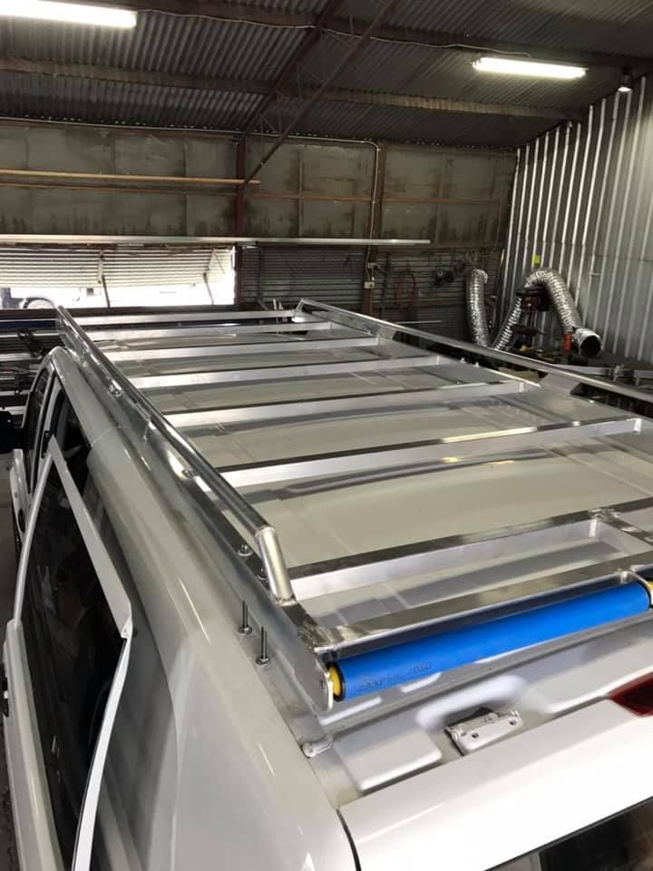 A White Van With a Roof Rack on It is Sitting in a Garage — Jensen Welding & Fabrication in Chevallum, QLD