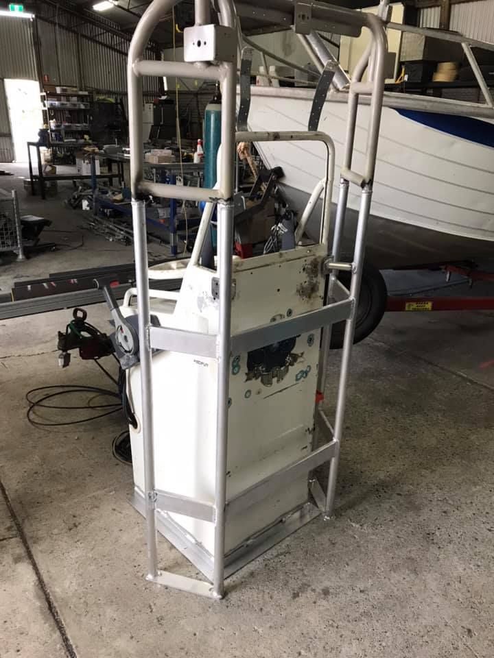 A Boat is Sitting on a Trailer in a Garage With a Ladder Attached to It — Jensen Welding & Fabrication in Chevallum, QLD