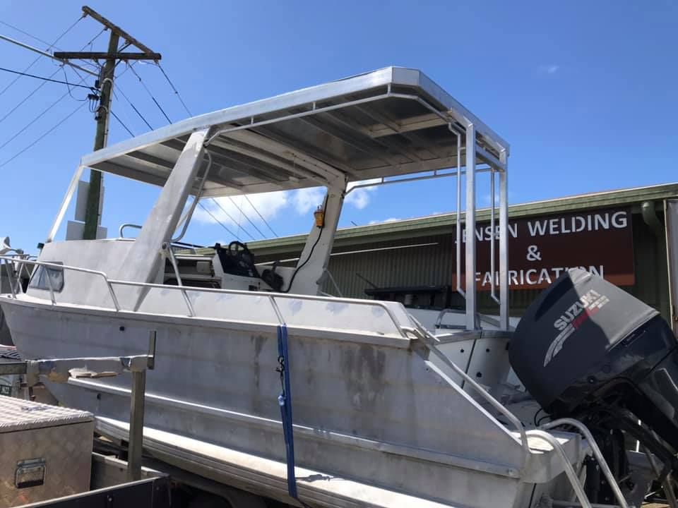 A Boat is Parked in Front of a Building That Says Welding and Fabrication — Jensen Welding & Fabrication in Chevallum, QLD