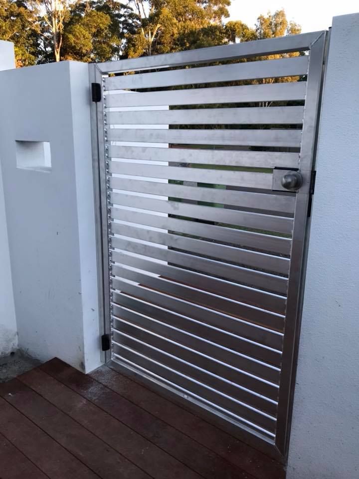 A Stainless Steel Gate With a Wooden Deck in Front of It — Jensen Welding & Fabrication in Chevallum, QLD