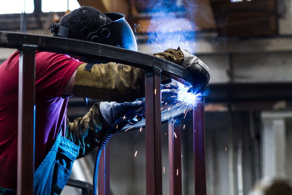 A Man is Welding a Piece of Metal in a Factory — Jensen Welding & Fabrication in Buderim, QLD