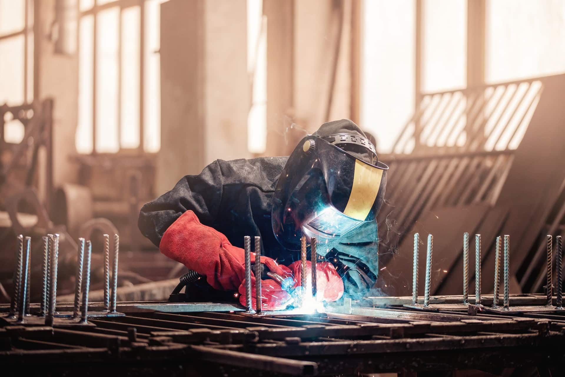 A Man is Welding a Piece of Metal in a Factory — Jensen Welding & Fabrication in Buderim, QLD