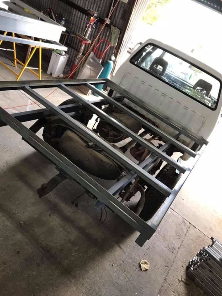 A White Truck is Sitting on Top of a Metal Frame in a Garage — Jensen Welding & Fabrication in Chevallum, QLD