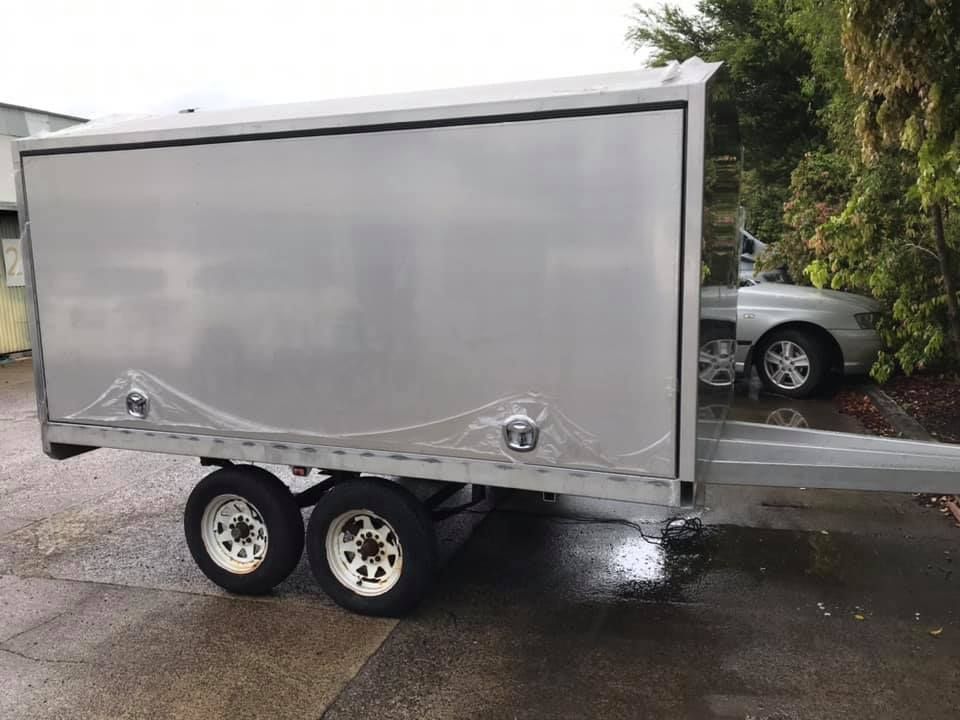 A Silver Trailer is Parked on the Side of the Road Next to a Car — Jensen Welding & Fabrication in Caloundra, QLD