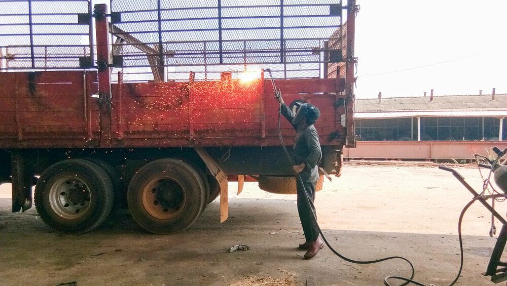A Man is Welding a Truck in a Garage — Jensen Welding & Fabrication in Chevallum, QLD