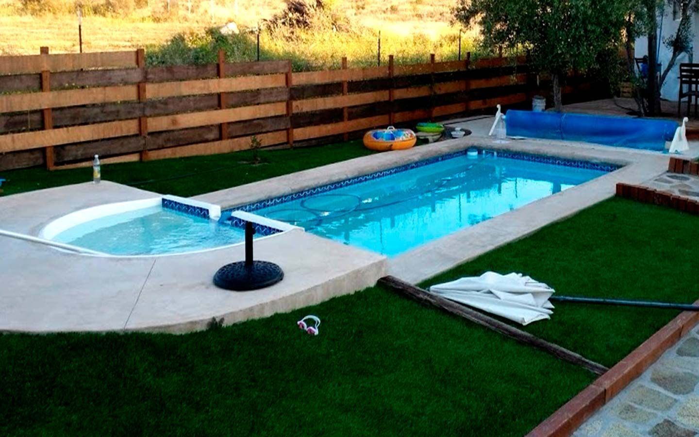 Una gran piscina con una valla de madera que la rodea.