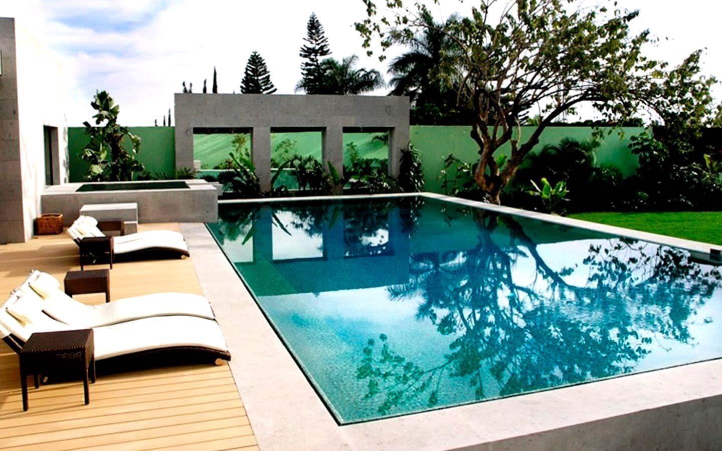 Una gran piscina rodeada de sillas y árboles.