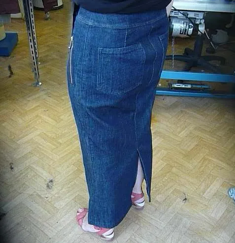 Une femme portant une longue jupe en jean avec une fermeture éclair dans le dos