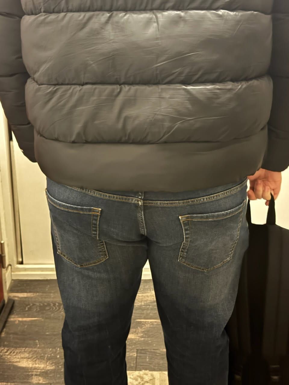 Le dos d'une personne portant un jean et une veste noire