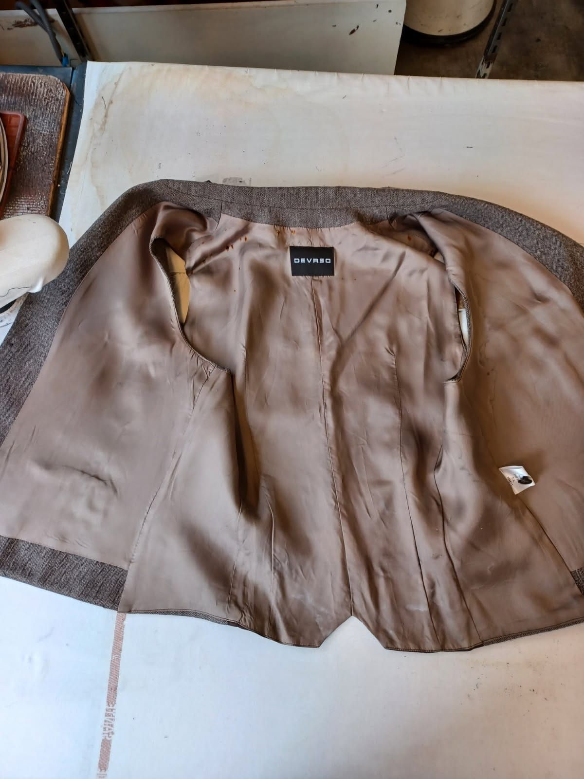 L'intérieur d'une veste marron est montré sur une table.