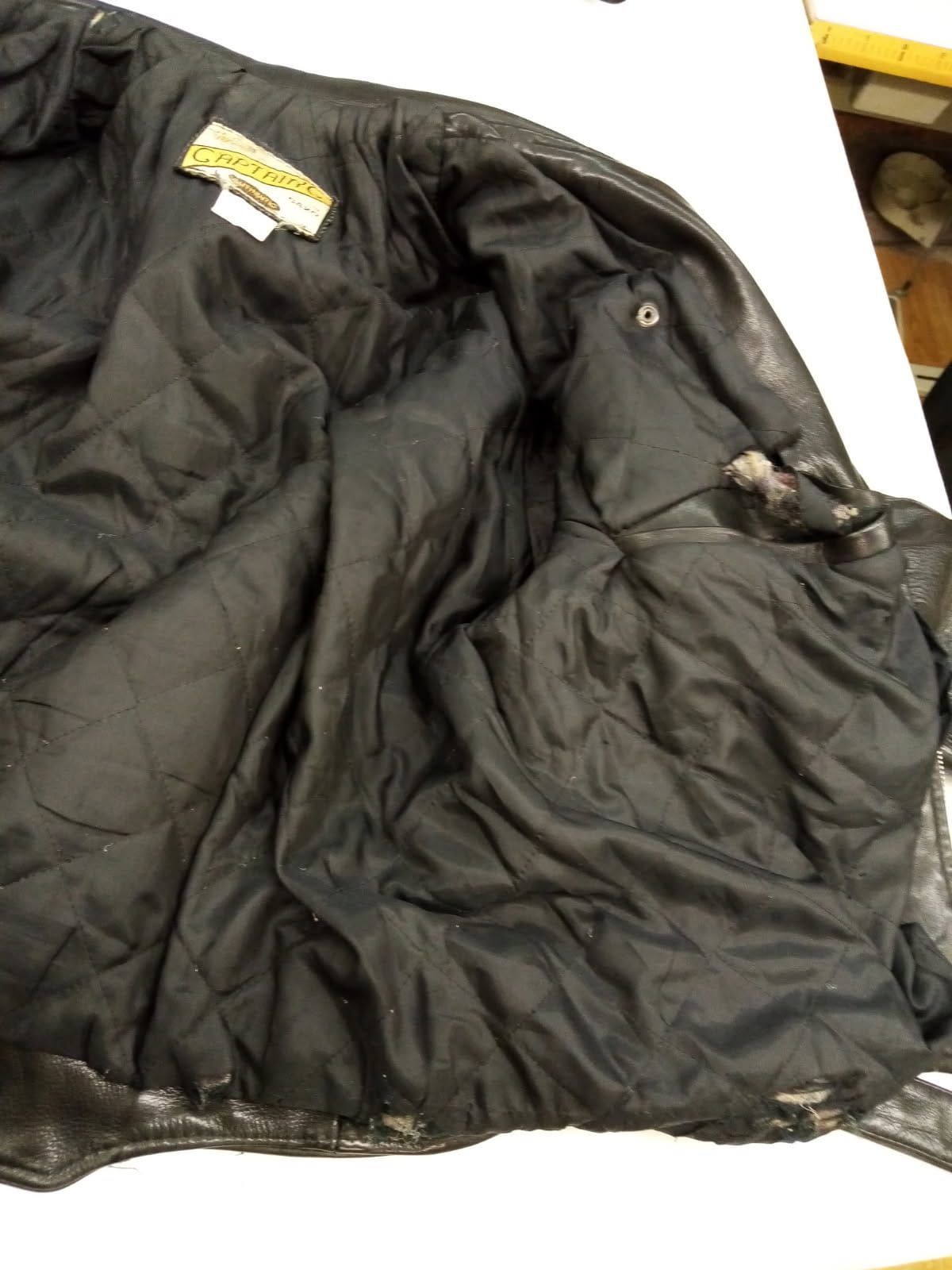 L'intérieur d'une veste en cuir noir porte une étiquette indiquant Harley Davidson