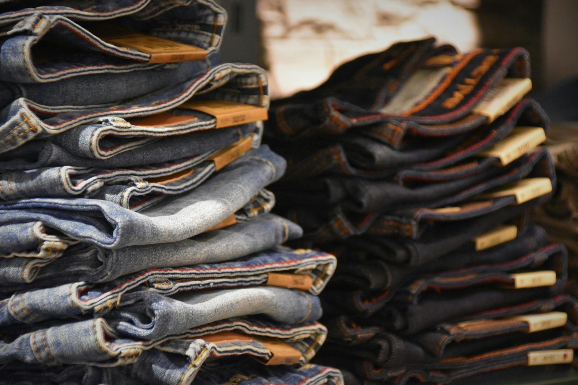 Une pile de jeans est posée les uns sur les autres sur une table.