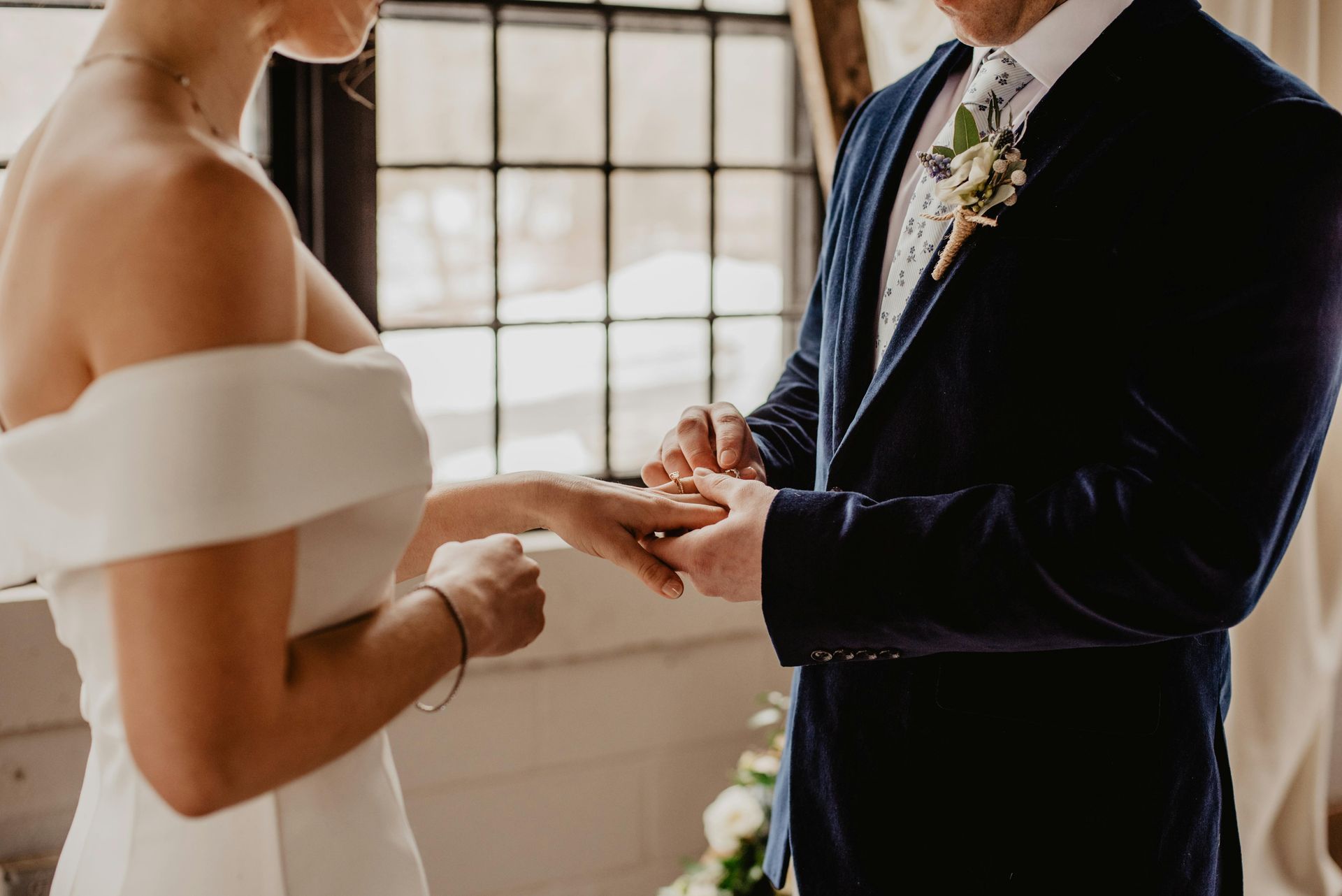 Une mariée et un marié se marient et la mariée met la bague au doigt du marié.