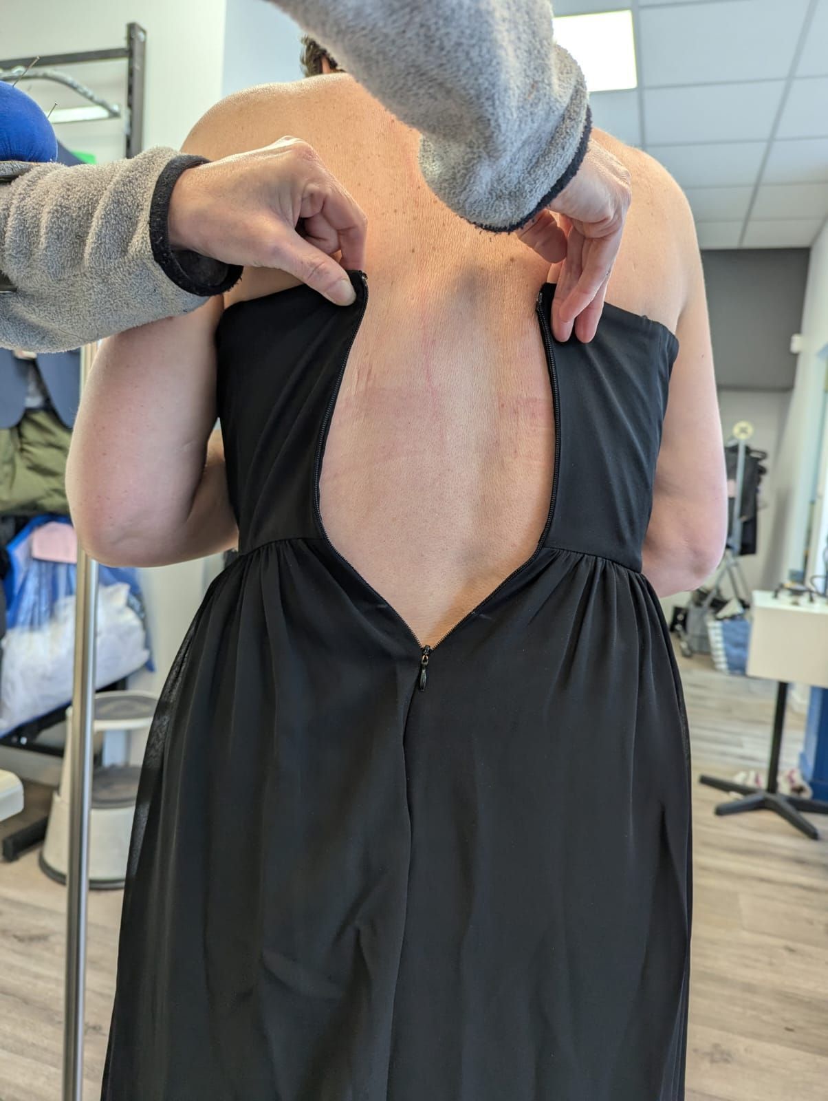 Une femme en robe noire avant la retouche