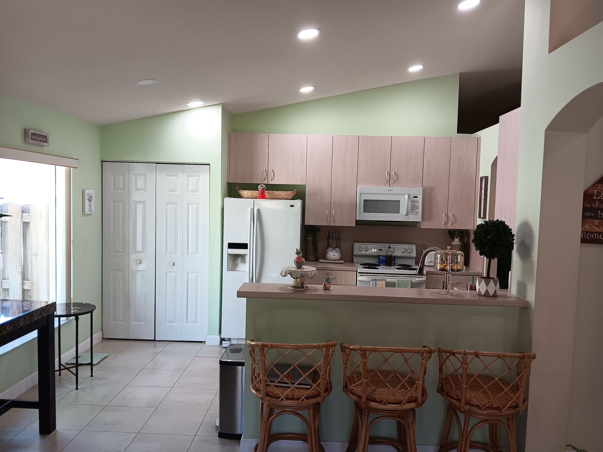 Person assembles flat-pack furniture on the floor. Brown cabinet components, cardboard boxes, and a couch in background.