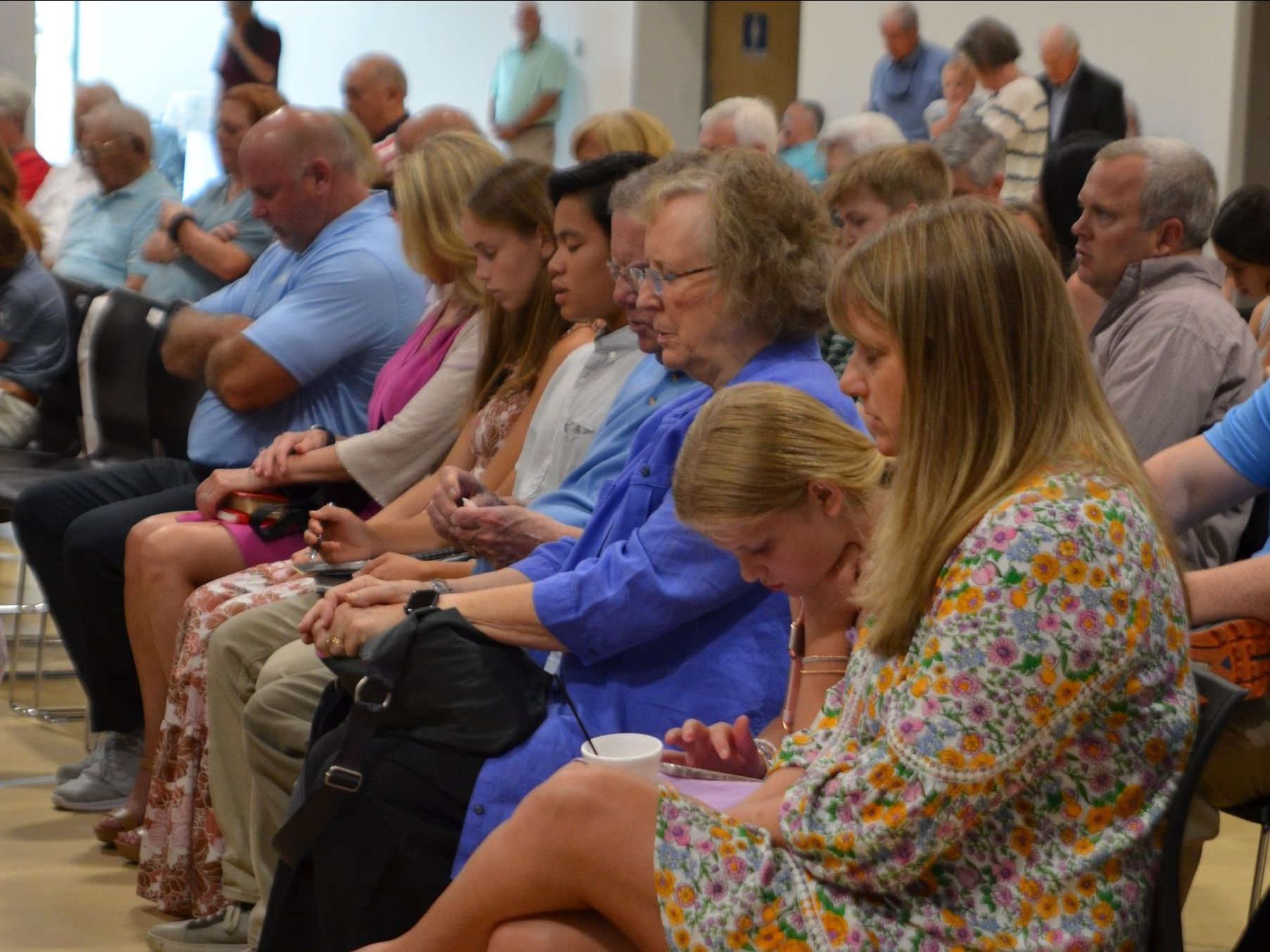 Praying during SGMC worship.a room.