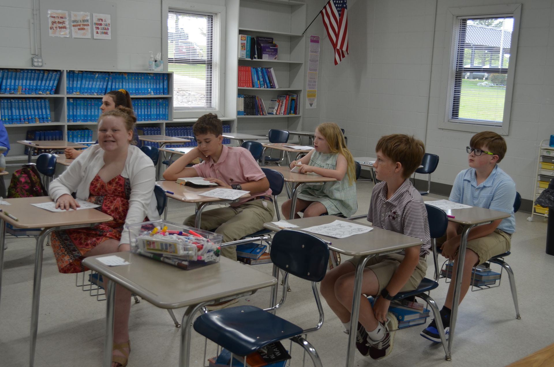A group of children are sitting at desks in a classroom.